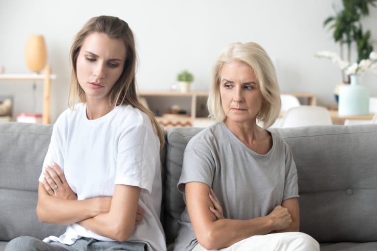 To kvinder på sofa To kvinder sidder på en sofa med armene over kors